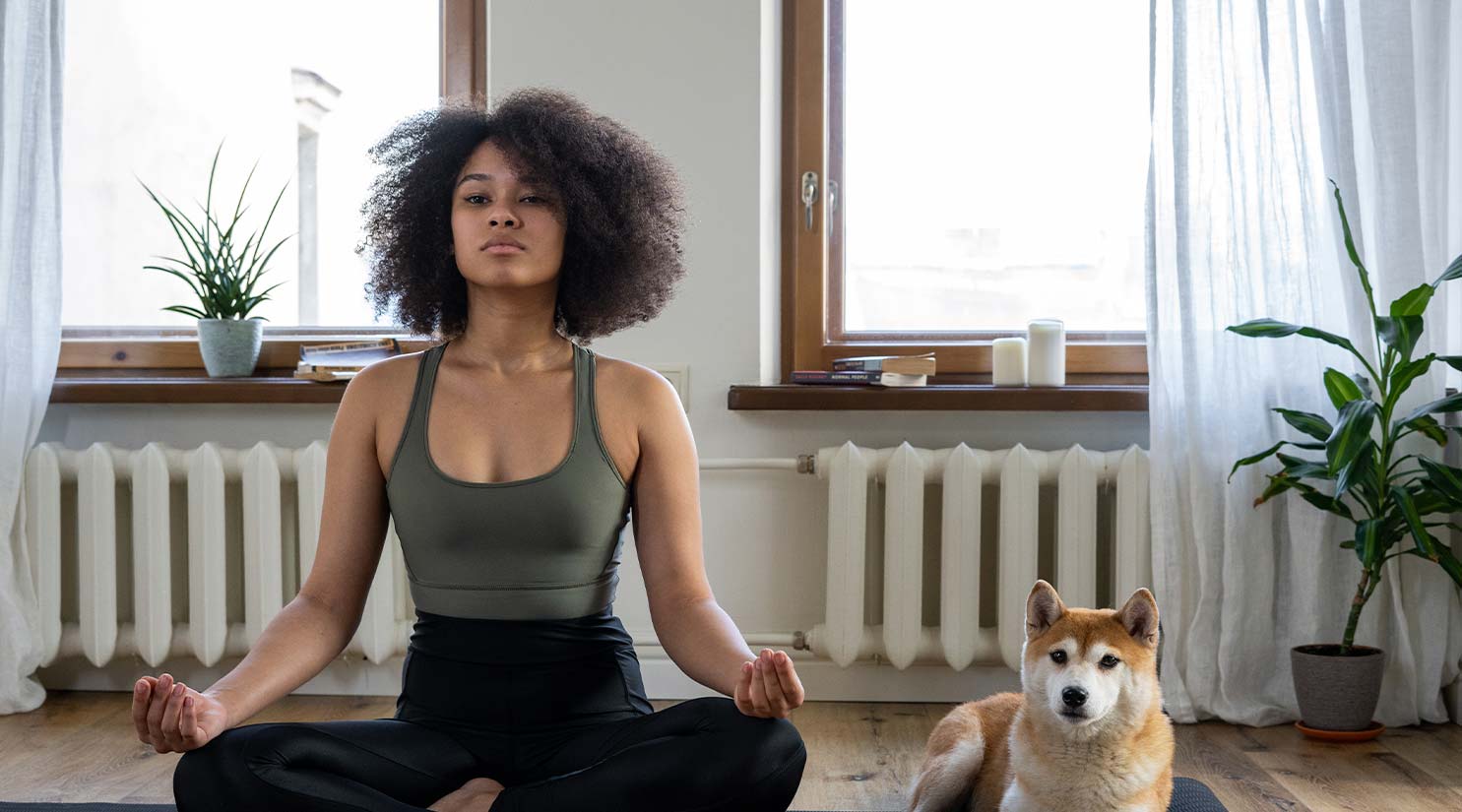 Woman doing Yoga with DOg at her Side Woman doing Yoga with Dog at her Side